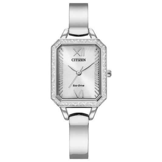 The CITIZEN Silhouette Crystal Eco-Drive 23mm Watch is a silver ladies timepiece featuring a rectangular face with Roman numerals at 12 and 6, complemented by a gem-encrusted bezel. Its sleek metallic band enhances the minimalist and elegant design of this CITIZEN watch.