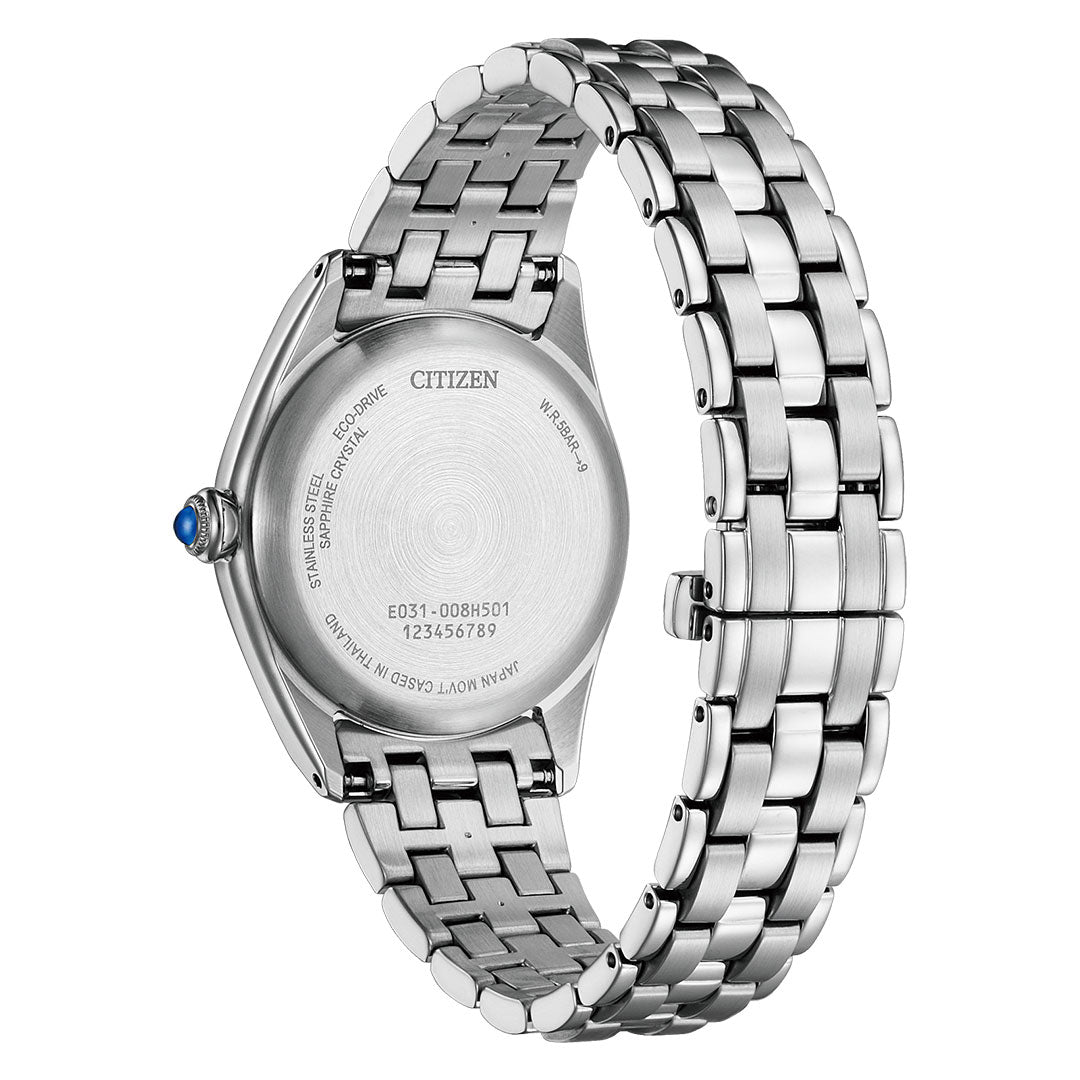 The image shows the back of a CITIZEN Classic L Eco-Drive 33mm women's stainless steel watch with a metal link band, engraved case back, model and serial numbers, and a small blue gemstone set in the crown.