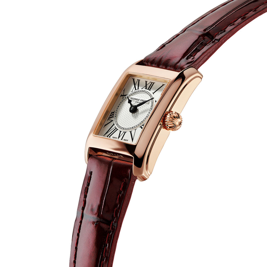 A Frederique Constant Classics Carree Quartz 23mm x 21mm watch in rose gold, featuring a rectangular case, brown leather strap, Roman numeral markers, and a white textured dial—an elegant women’s timepiece inspired by the classic square shape, photographed on a white background.