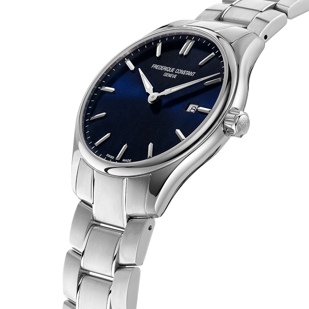 The Frederique Constant Classics Quartz 40mm Watch features a silver stainless steel case, navy blue dial, silver markers and hands, and a date window at 3 o’clock, shown angled on a white background.