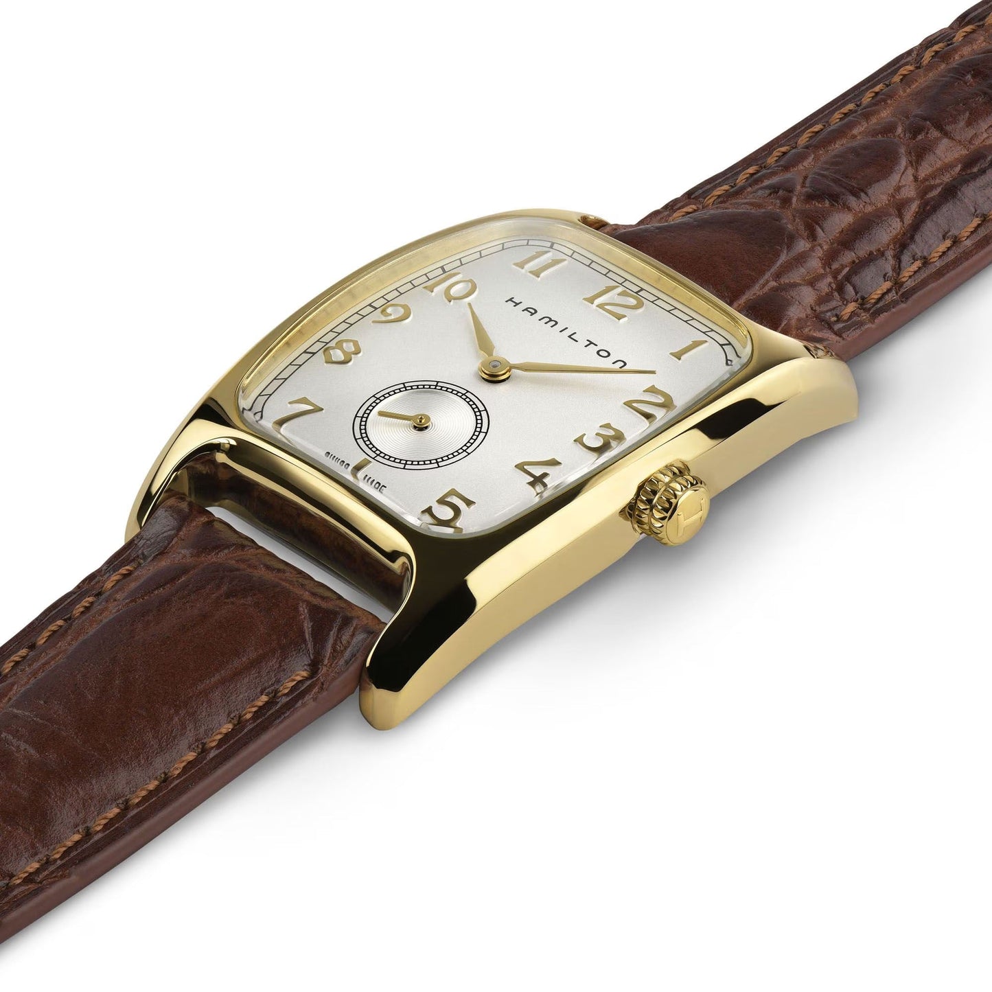 A Hamilton American Classic Boulton Quartz 27mm x 32mm watch by Hamilton Watch, featuring a gold rectangular case, white dial with gold numerals and hands, small seconds subdial, and brown leather strap, displayed angled on white.