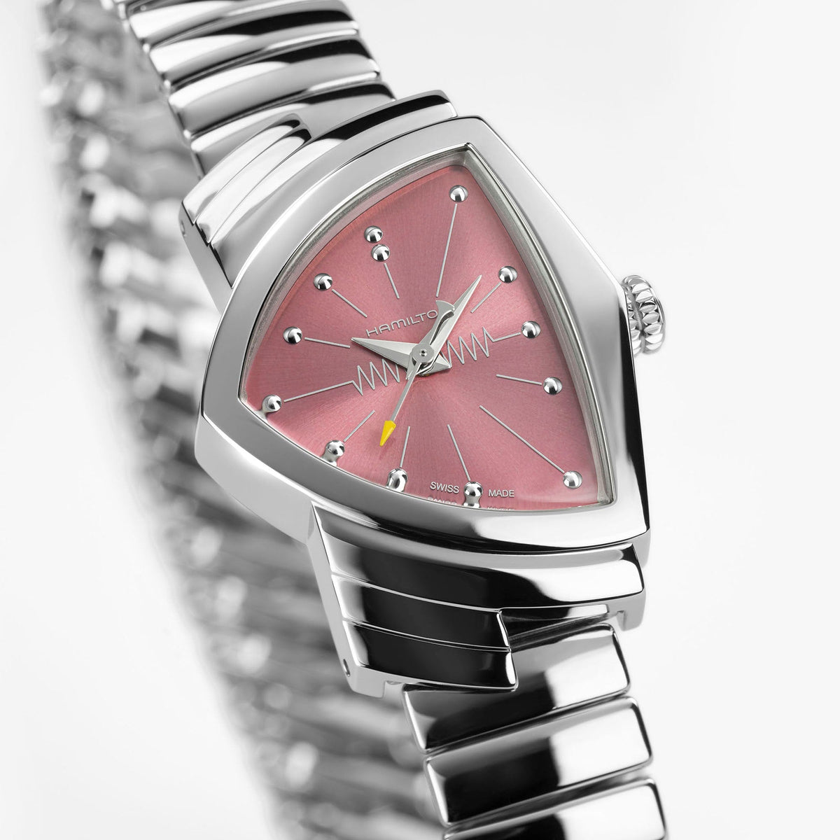 A Hamilton Ventura S Quartz 24mm x 36mm watch by Hamilton Watch, featuring a silver stainless steel bracelet and triangular pink dial adorned with a distinctive zigzag pattern, displayed against a white background.