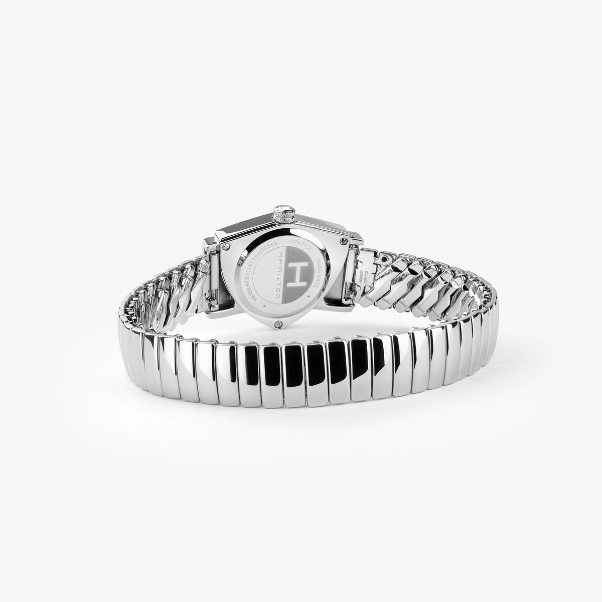 The Hamilton Ventura S Quartz 24mm x 36mm watch by Hamilton Watch is shown from the back, highlighting its round case, engraved markings, and flexible, segmented stainless steel bracelet against a white background.