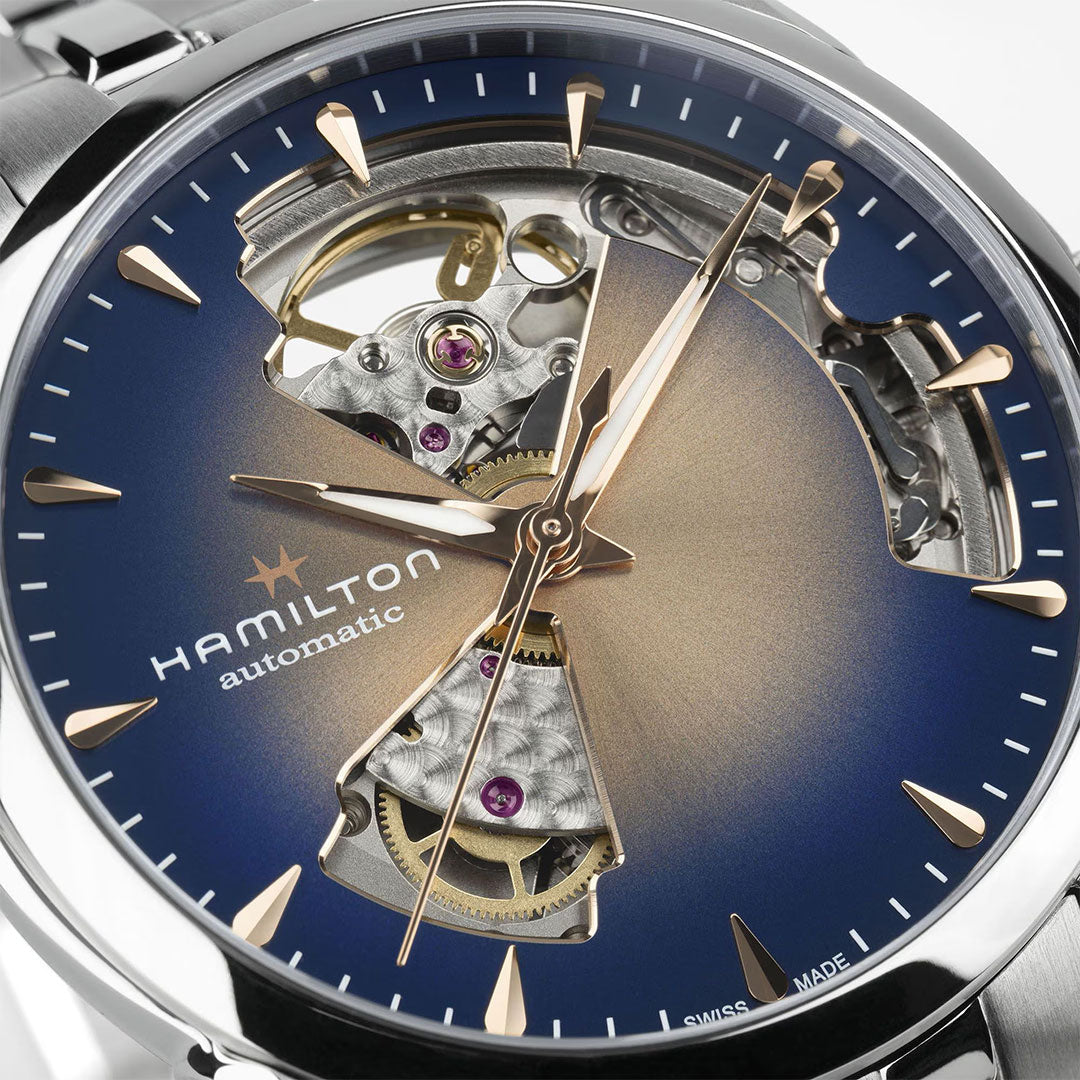 Close-up of the Hamilton Jazzmaster Open Heart Lady Auto 36mm Watch by Hamilton Watch, featuring a blue and gold gradient dial with gold-toned hands and indices, along with an open-heart design revealing its inner gears.