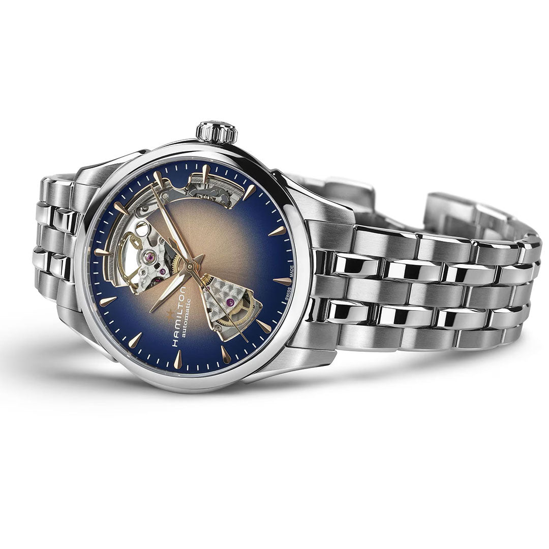 The Hamilton Jazzmaster Open Heart Lady Auto 36mm features a silver metallic band, blue gradient dial, partially skeletonized design, and exposed mechanics. The "Hamilton Watch" brand is displayed on the watch face.