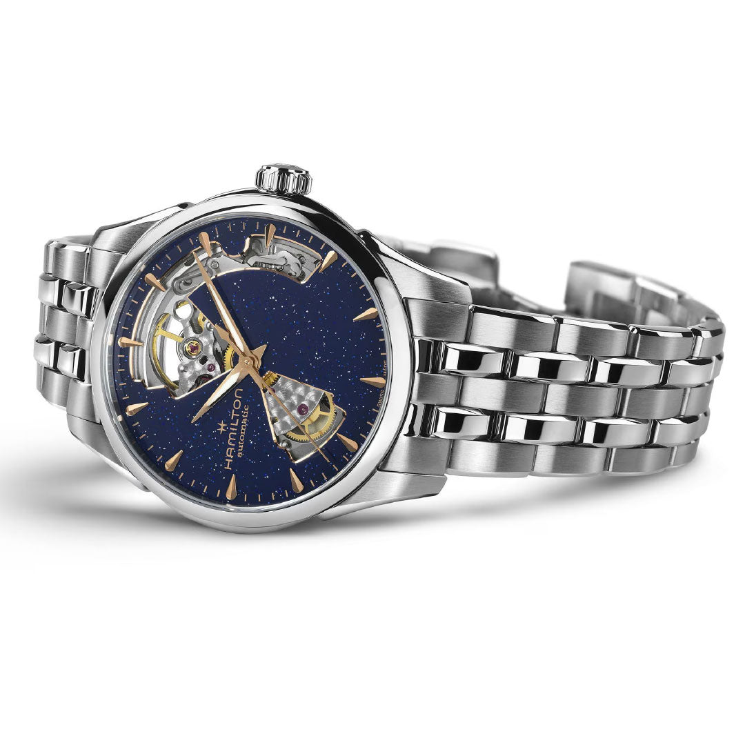 The Hamilton Jazzmaster Open Heart Lady Auto 36mm Watch by Hamilton Watch features a stainless steel case, dark blue star-patterned dial with gold markers, visible automatic movement, and metal link bracelet—ideal for dress watch enthusiasts.