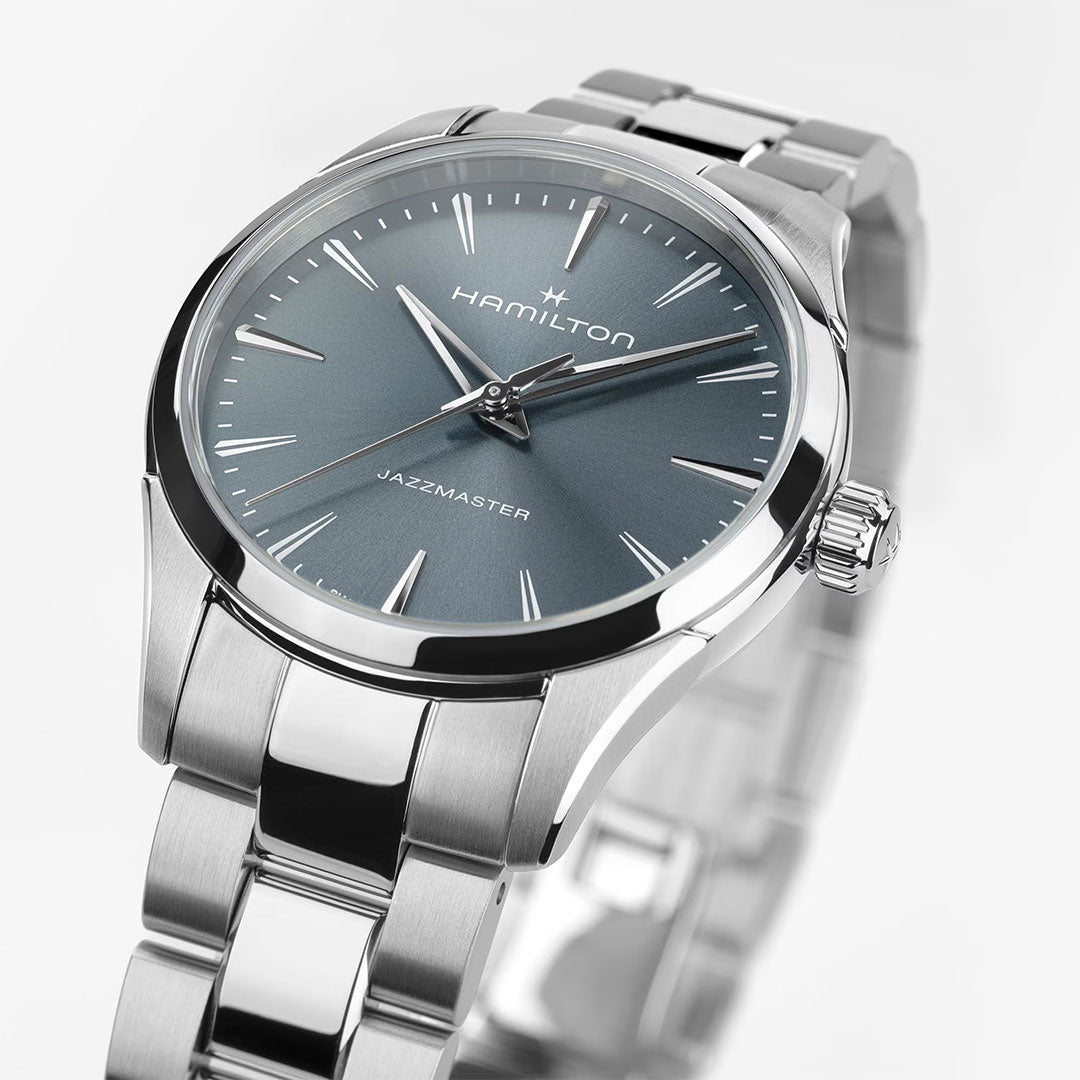 The Hamilton Jazzmaster Quartz 32mm Watch by Hamilton Watch features a silver case, blue sunray dial, silver hour markers, and a stainless steel band, shown in close-up against a white background.