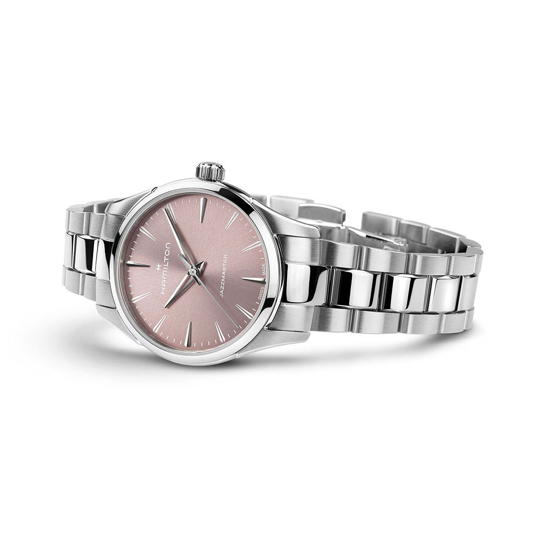 The Hamilton Jazzmaster Quartz 32mm Watch by Hamilton Watch features a pink dial, silver hour markers and hands, and a silver metallic link band, creating an elegant dress watch displayed on a white background.