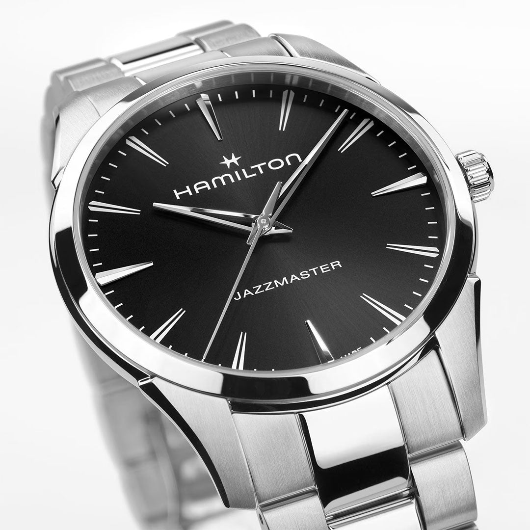A close-up of the Hamilton Watch Jazzmaster Quartz 40mm, featuring a black dial, silver hour markers, and a stainless steel band, showcased on a white background.