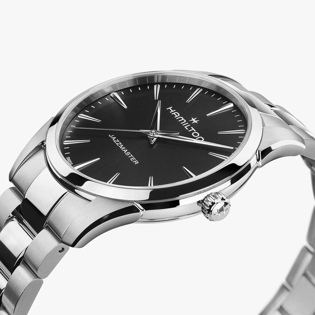 A close-up of the Hamilton Watch Jazzmaster Quartz 40mm features a black dial, silver markers, and stainless steel bracelet, highlighting its minimalist design against a white background.