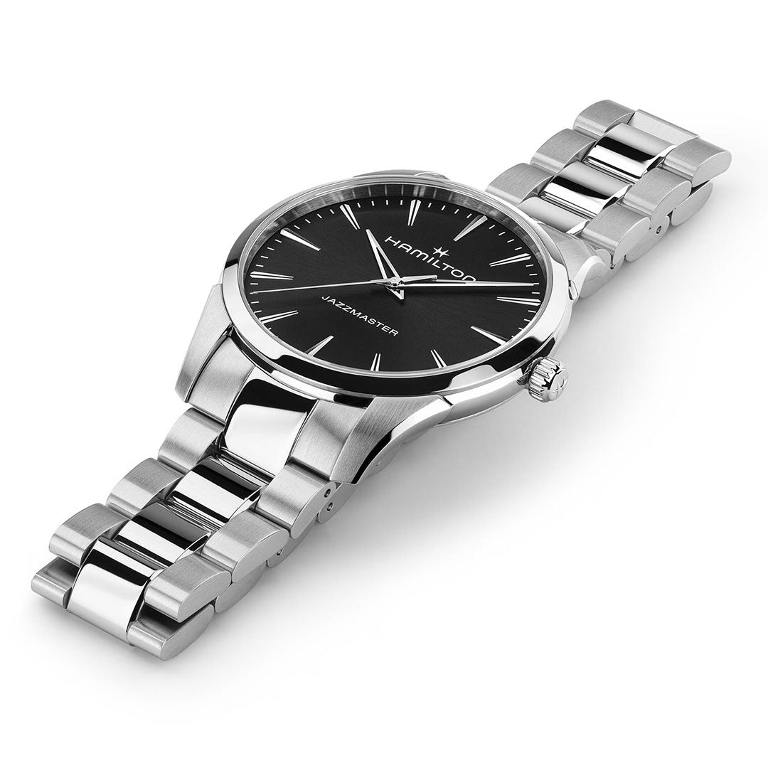 The Hamilton Jazzmaster Quartz 40mm Watch by Hamilton Watch features a black dial with silver hour markers and a stainless steel metal link bracelet, displayed at an angle on a white background.
