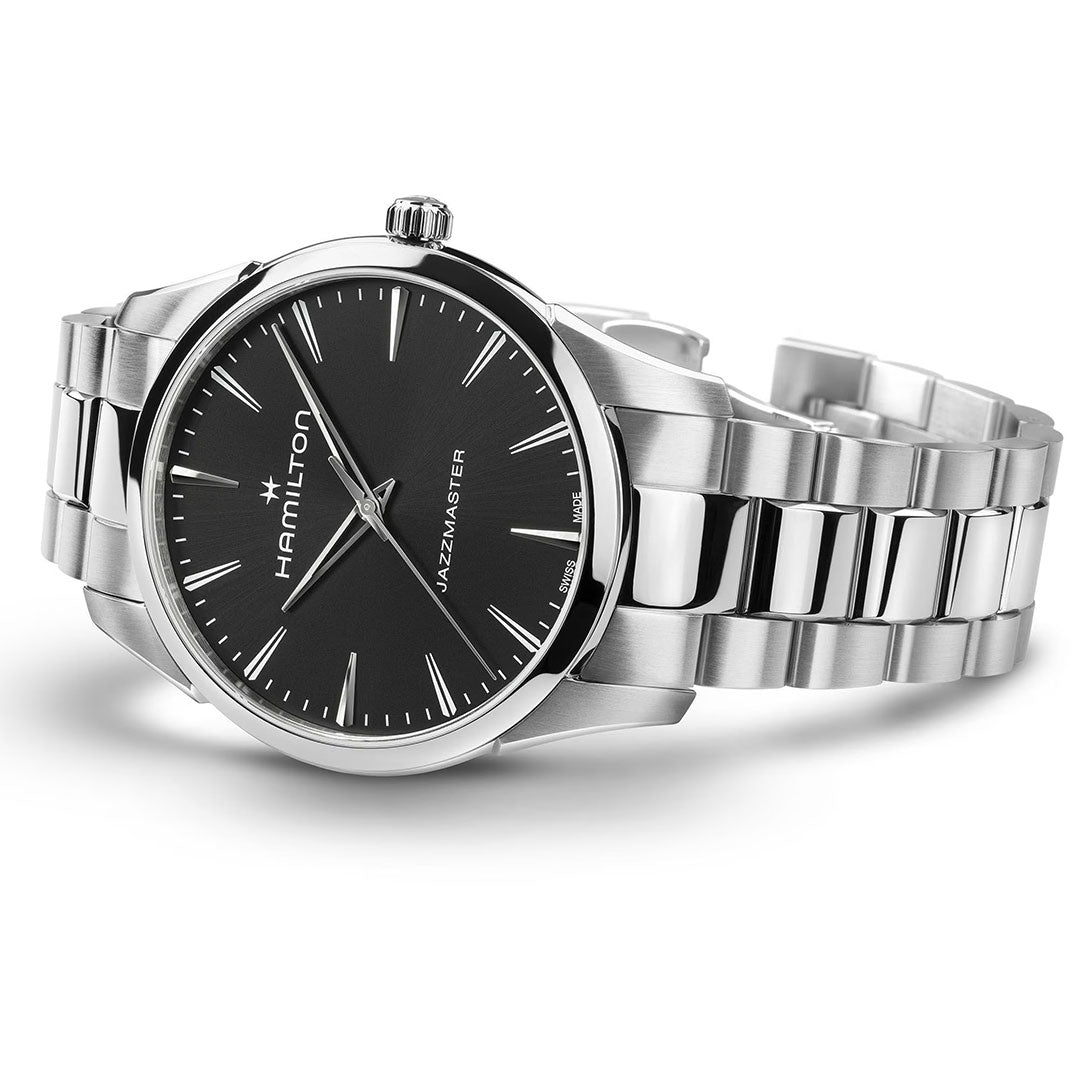 A Hamilton Jazzmaster Quartz 40mm Watch by Hamilton Watch, featuring a black dial, silver hour markers, and a stainless steel bracelet, is shown on its side with the brand name and minimalist design visible on the face.