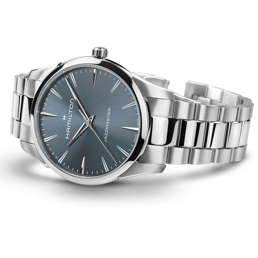 The Hamilton Jazzmaster Quartz 40mm Watch by Hamilton Watch is shown at an angle on a white surface, featuring a metallic bracelet and blue dial with silver hour markers and hands.