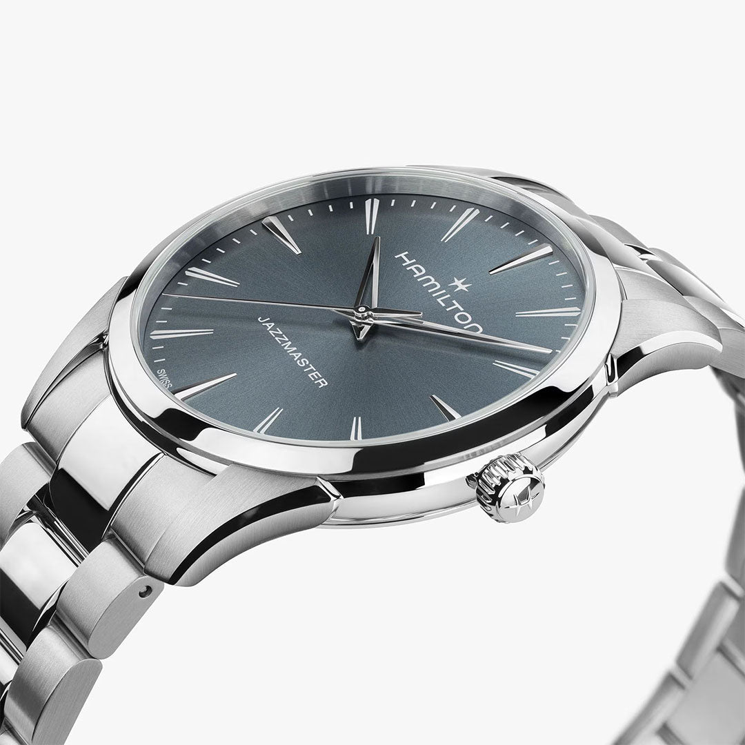 The Hamilton Jazzmaster Quartz 40mm Watch by Hamilton Watch is shown at an angle on a white background, featuring a silver metal bracelet, blue dial, silver hour markers, and a crown embossed with the brand's logo.
