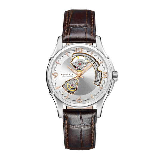 The Hamilton Jazzmaster Open Heart Auto 40mm Watch by Hamilton Watch showcases a silver wristwatch with an open heart dial that reveals intricate gears. It features a brown leather strap, a silver casing, and partially visible mechanical movement, along with detailed numerals and a prominent brand emblem.