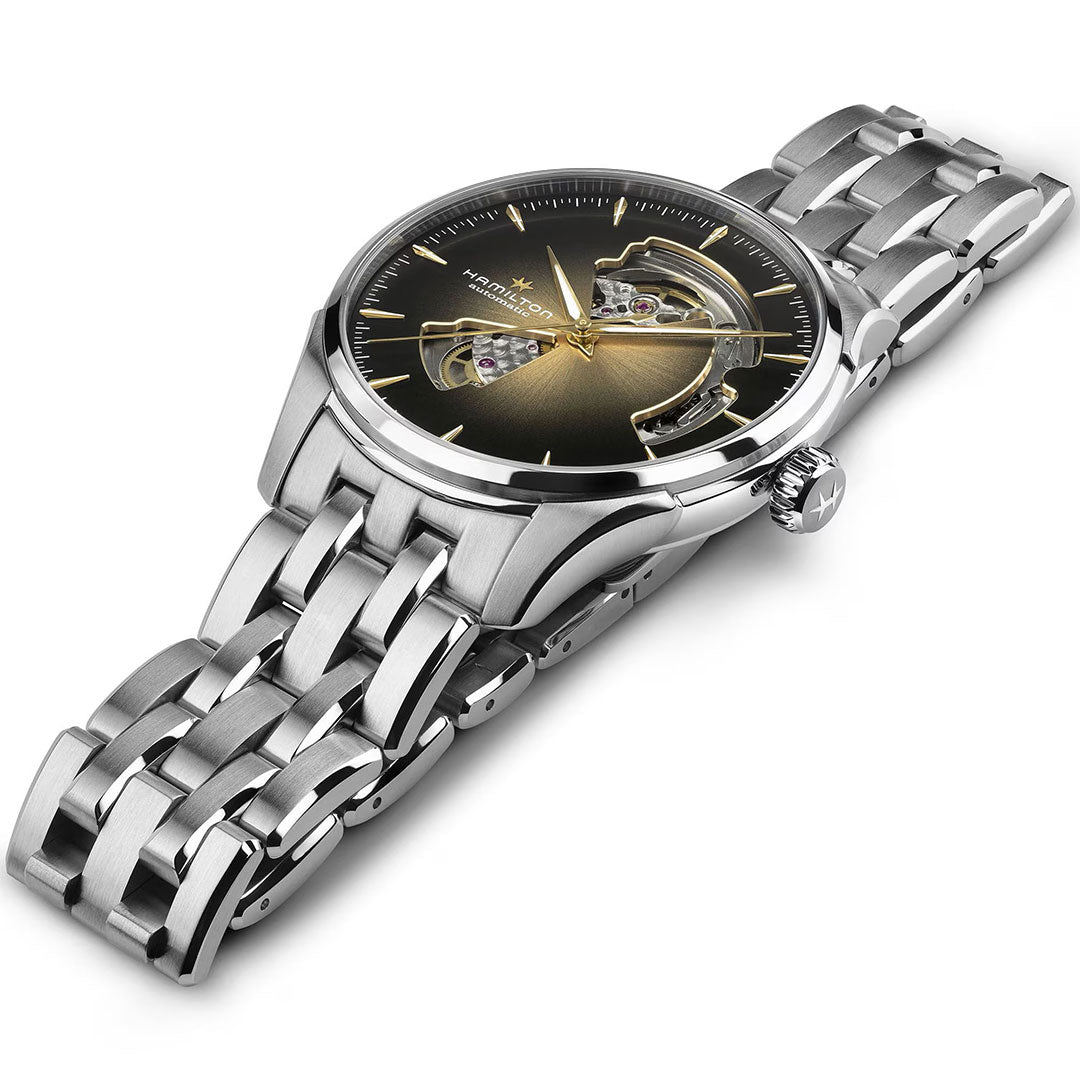 The Hamilton Jazzmaster Open Heart Auto 40mm Watch by Hamilton Watch features a round black and gold gradient dial, gold hour markers, an open-heart mechanical movement display, and a sleek stainless steel band.