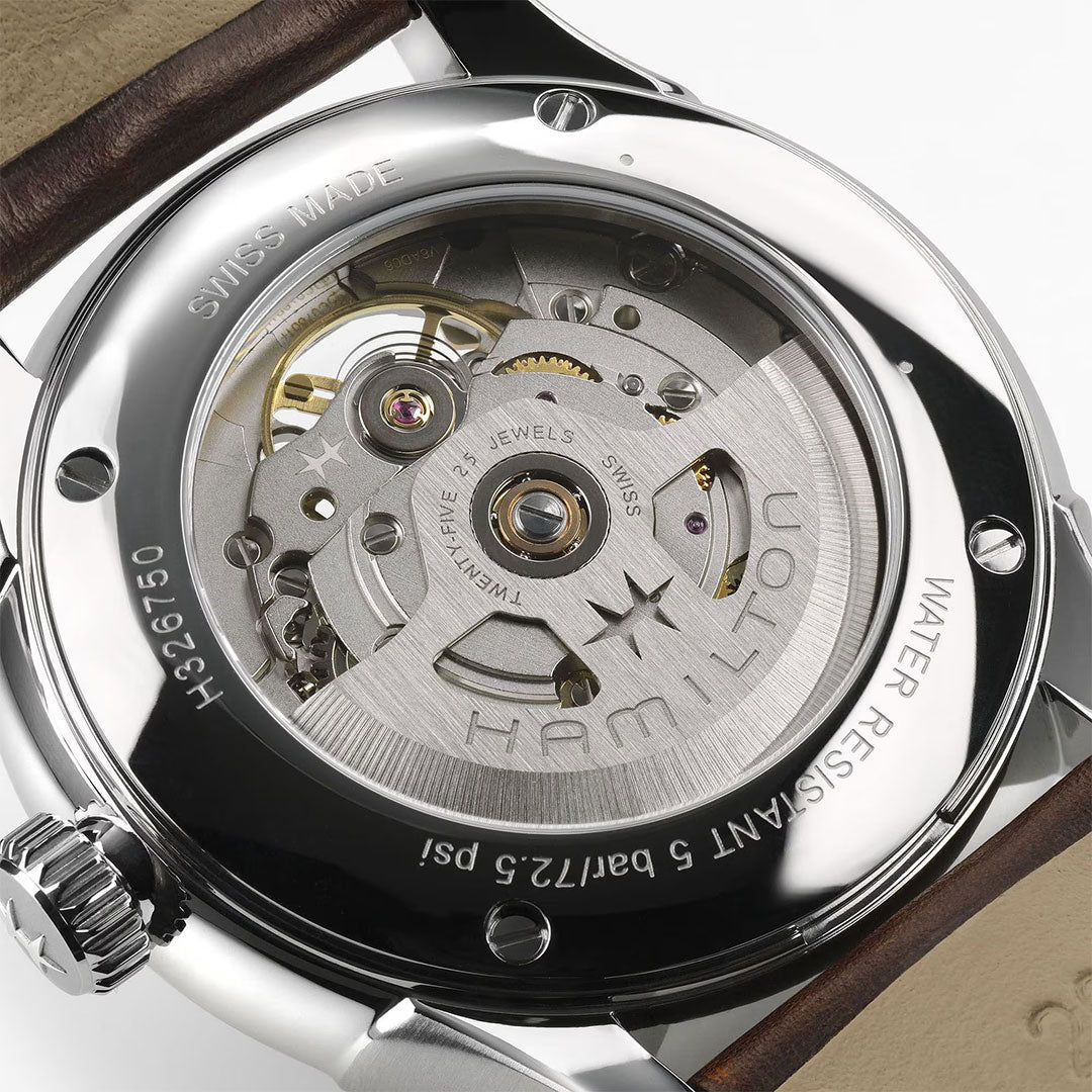 Close-up of the Hamilton Jazzmaster Open Heart Auto 40mm Watch by Hamilton Watch, showing its transparent caseback with visible mechanical movement and engravings, complemented by a refined brown leather strap.