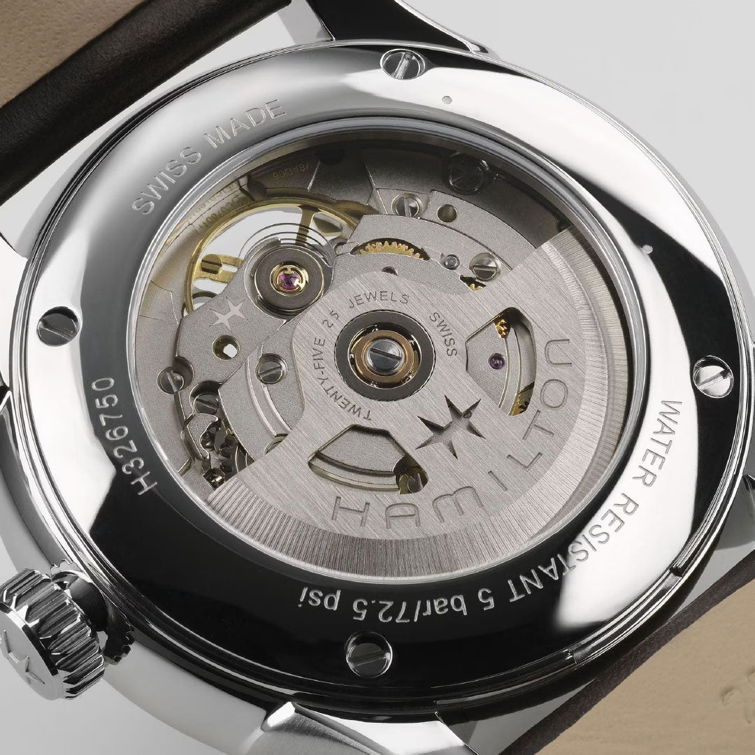 Close-up of the back of the Hamilton Jazzmaster Open Heart Auto 40mm Watch by Hamilton Watch, highlighting the exposed H-10-S automatic movement, visible gears, and stainless steel case with “SWISS MADE” and “WATER RESISTANT” markings.