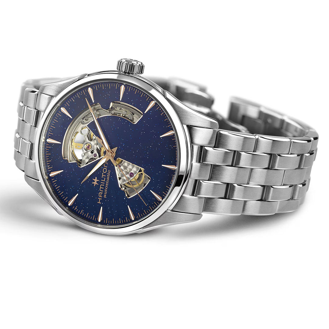 The Hamilton Jazzmaster Open Heart Auto 42mm by Hamilton Watch features a metallic bracelet, blue star-speckled dial, gold hour markers, and an open-heart display—ideal for those who appreciate elegant dress watches.