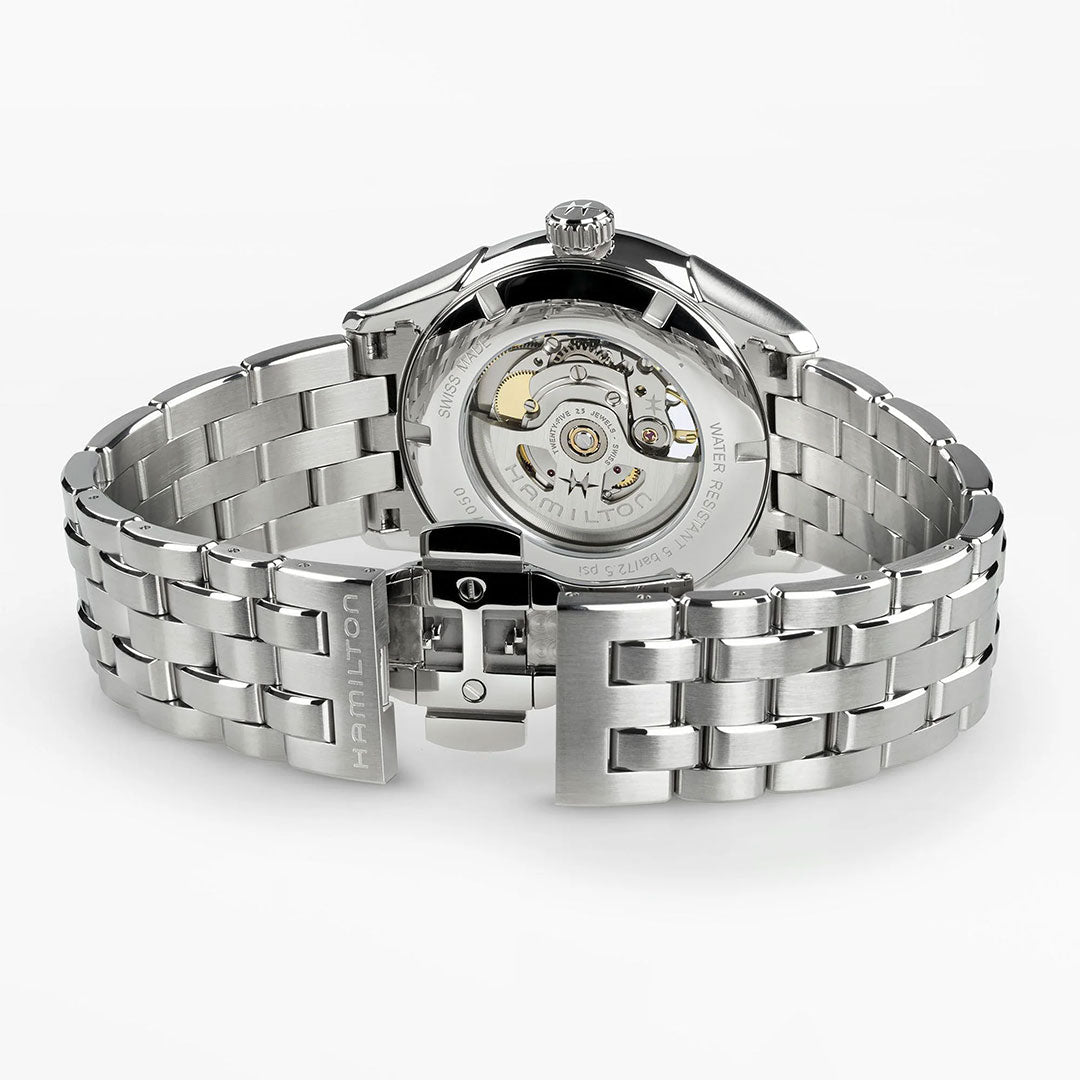 The Hamilton Jazzmaster Open Heart Auto 42mm Watch features a silver case, stainless steel bracelet, transparent case back, visible mechanical movement, and "Hamilton" engraved on the clasp.