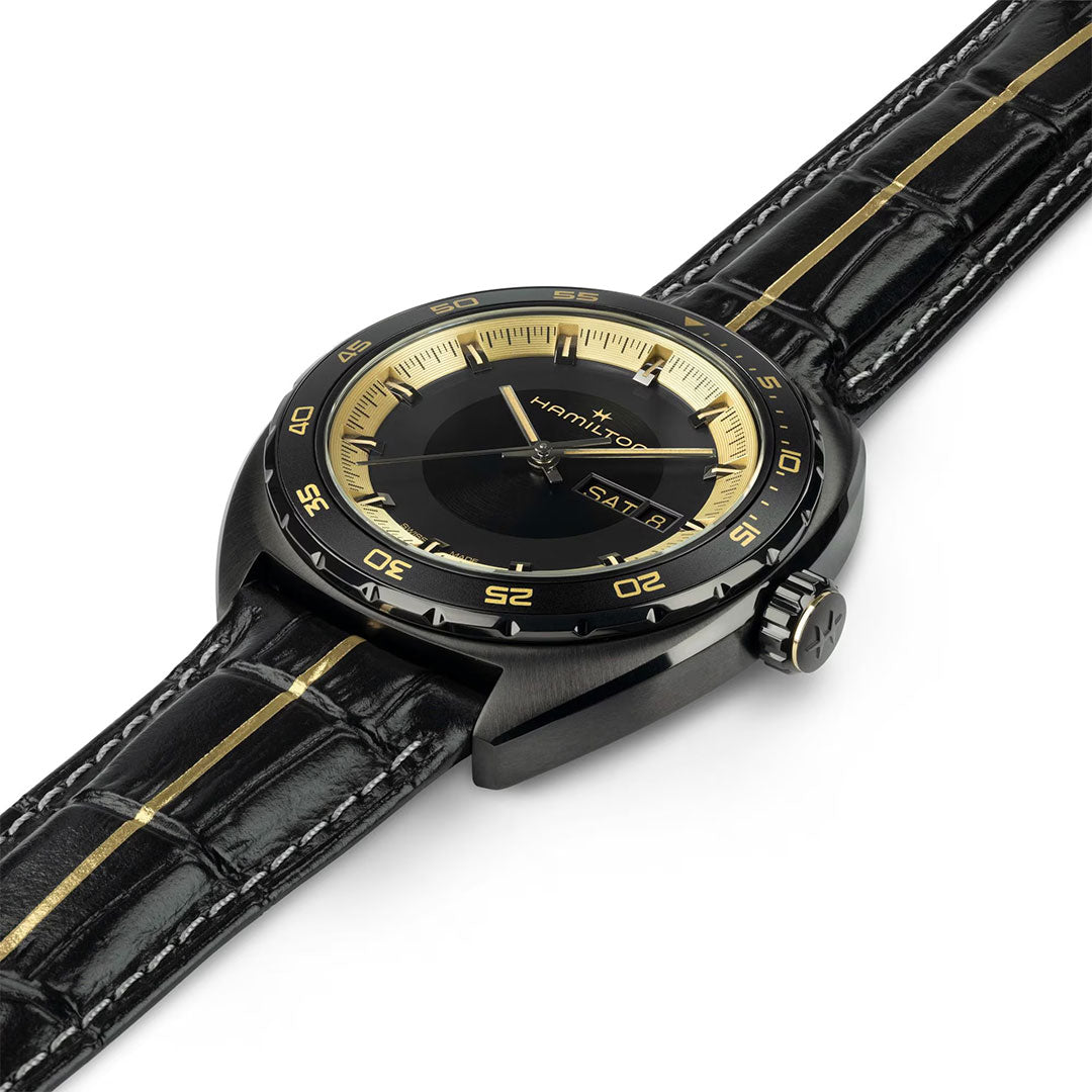 The Hamilton American Classic Pan Europ Resident Evil Requiem Limited Edition Auto 42mm Watch by Hamilton Watch features a black and gold design, crocodile-pattern leather strap, gold accents, day/date display, and modern style.