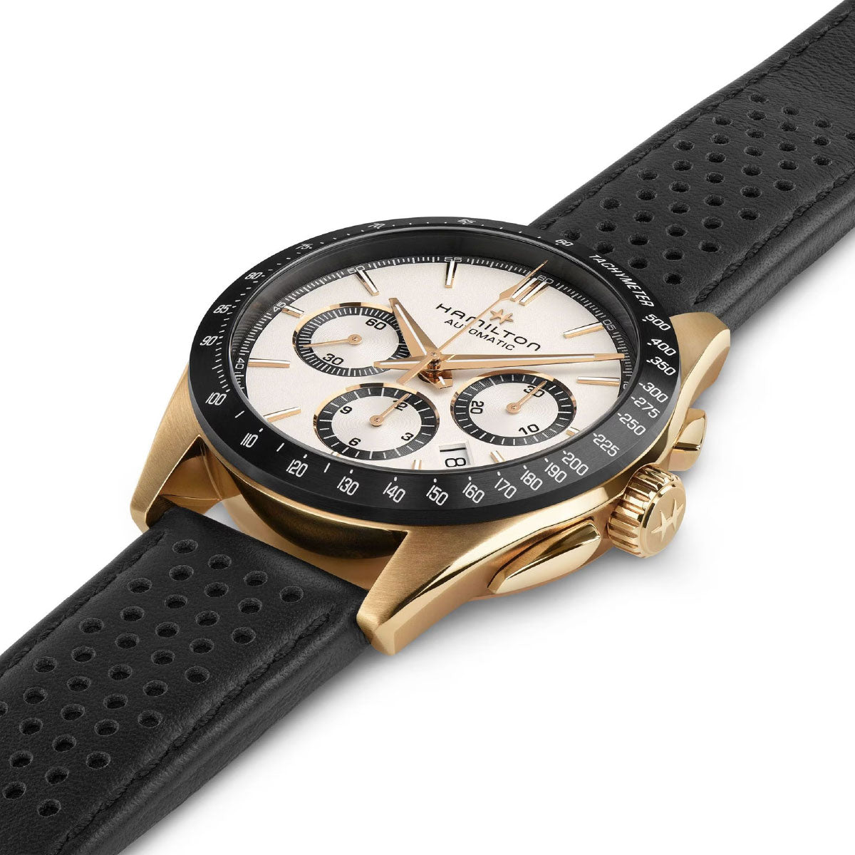 The Hamilton Jazzmaster Performer Auto Chrono 42mm Watch, crafted by Hamilton Watch, is a luxury wristwatch featuring a gold-tone case, black perforated leather strap, and white dial. It boasts three subdials and gold hour markers, offering a perfect blend of sport-chic aesthetics with elegance and functionality.