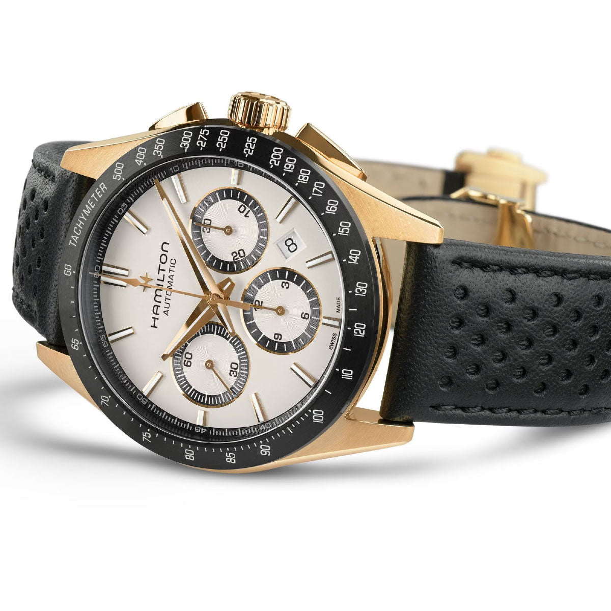 The Hamilton Jazzmaster Performer Auto Chrono 42mm Watch is a luxury timepiece with a sport-chic aesthetic, featuring a gold and black case, white face, three sub-dials, and date display. It boasts an automatic chronograph movement and comes with a black perforated leather strap. The "Hamilton" name is prominently displayed on the dial.