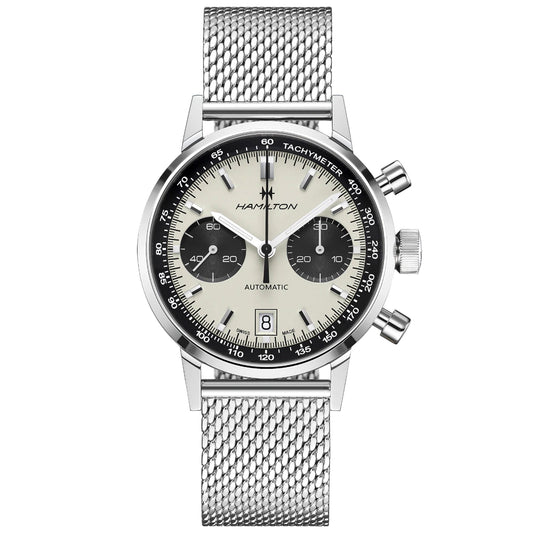 The Hamilton American Classic Intra-Matic Auto Chrono 40mm Watch, from the renowned Hamilton Watch brand, features a classic round design with a silver mesh strap. It showcases a panda dial and an automatic chronograph movement. This timepiece is equipped with three subdials, a date display at the 6 o'clock position, and tachymeter markings on the bezel. The brand name "Hamilton" is prominently displayed on the dial.