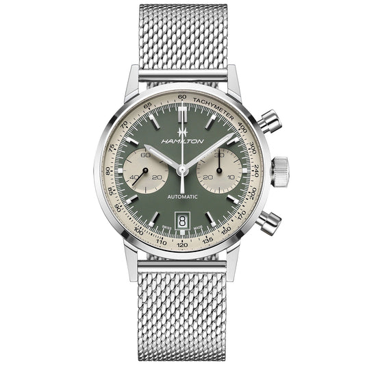 The Hamilton American Classic Intra-Matic Auto Chrono 40mm Watch boasts a silver case paired with a mesh band and highlights a panda dial featuring a green and beige face. It includes a tachymeter scale and two subdials, complemented by white hands and markers alongside a date window positioned at 6 o'clock. The "Hamilton Watch" brand name is elegantly displayed beneath the 12 o'clock marker.