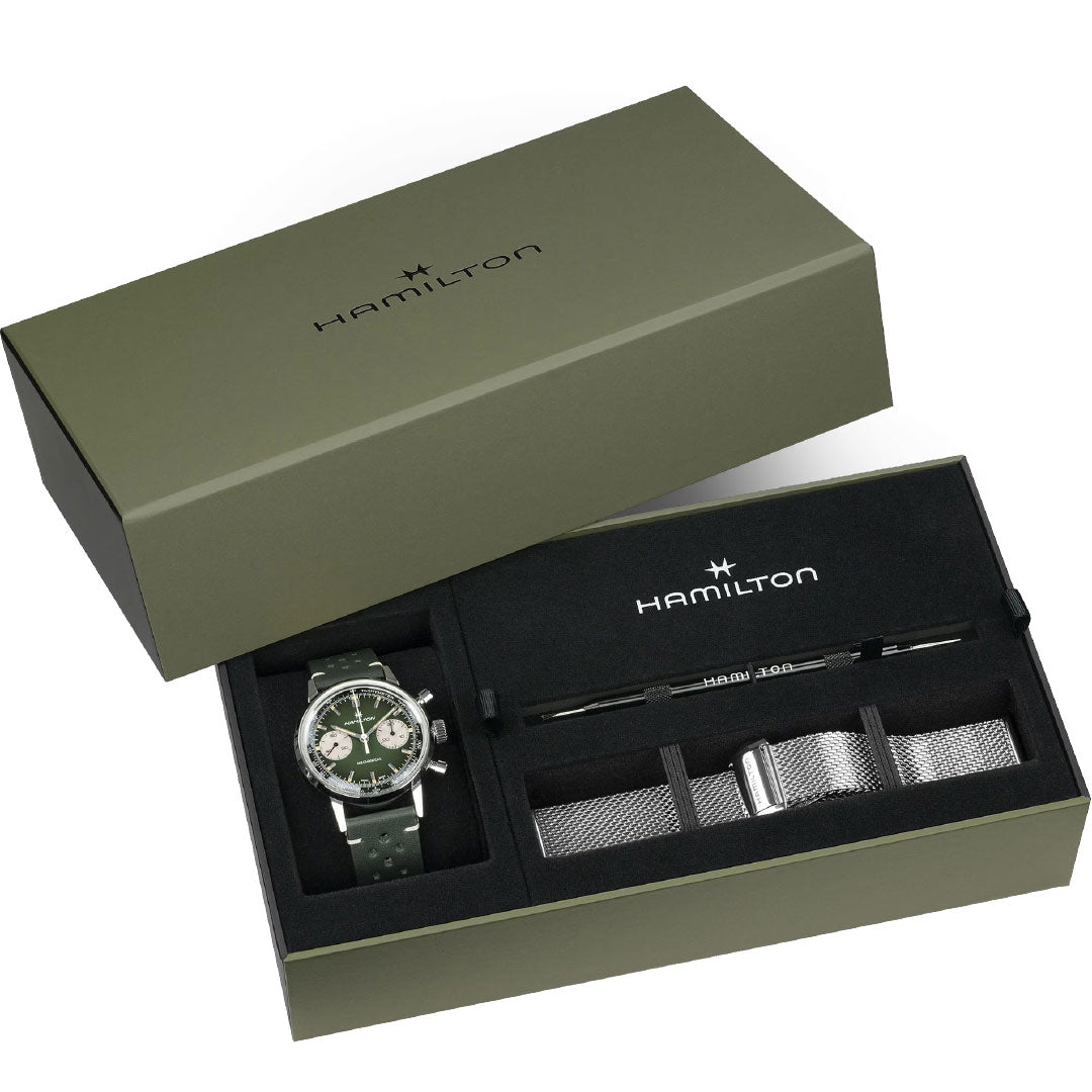 A green Hamilton gift set box with a Hamilton American Classic Intra-Matic Mechanical Chronograph H 40mm watch (two-tone, green strap), a silver mesh strap, and a strap-changing tool, all neatly arranged inside.