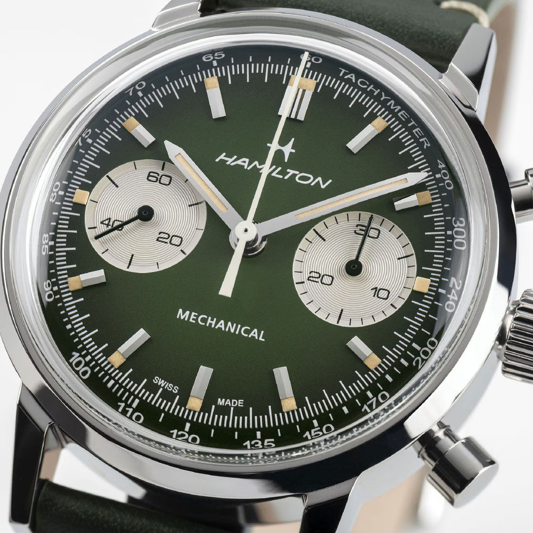 Close-up of the Hamilton American Classic Intra-Matic Mechanical Chronograph H 40mm by Hamilton Watch, featuring a green dial with two subdials, tachymeter, silver hands, white hour markers, and black leather strap—ideal for vintage racing fans.