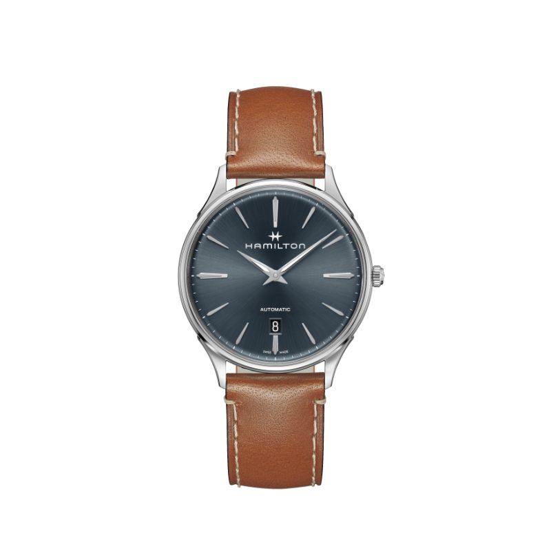 The Hamilton Jazzmaster Thinline Auto 40mm watch from Hamilton Watch features a dark blue dial accentuated by silver hour markers and hands, housed in a silver casing with a brown leather strap. It boasts an "Automatic" label on the dial and includes a date display located at the 6 o'clock position.