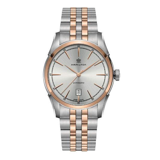 Presenting the Hamilton American Classic Spirit of Liberty Auto 42mm Watch, crafted with a luxurious silver and rose gold two-tone metal band. The elegant silver dial is adorned with slim rose gold markers and hands, along with a date display positioned at 6 o'clock. The Hamilton Watch brand name is elegantly displayed just below the 12 o'clock position.