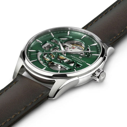 The Hamilton Jazzmaster Skeleton Auto 40mm Watch features a green skeleton dial with visible Swiss automatic movement, an 80-hour power reserve, a silver case, and a brown leather strap. Hamilton Watch branding and logo appear on the dial.