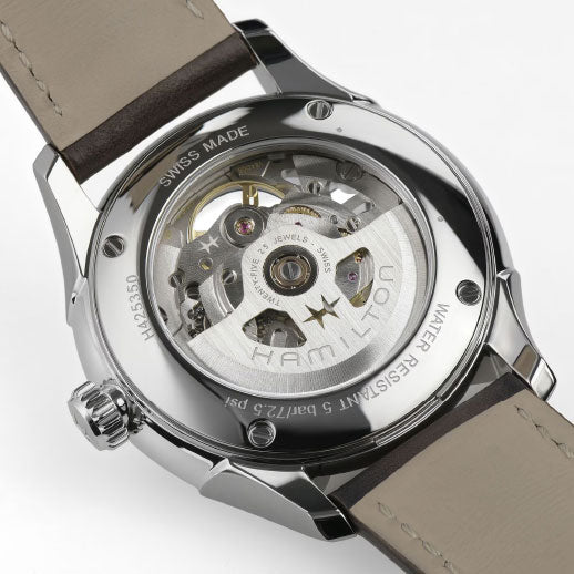 Close-up of the Hamilton Jazzmaster Skeleton Auto 40mm Watch by Hamilton Watch, revealing its Swiss automatic movement through a transparent case back with engravings for 80-hour power reserve, water resistance, Swiss Made, and model info.