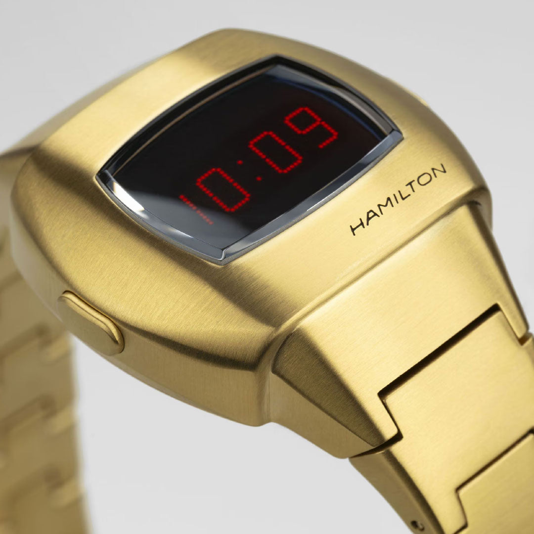 A close-up of the Hamilton American Classic PSR 74 Quartz 26mm x 31mm Watch by Hamilton Watch, featuring a gold brushed metal finish, rectangular face, and red LED display showing 10:09—evoking the iconic Cushion Pulsar style.