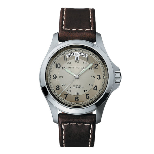 Introducing the Hamilton Khaki Field King Auto 40mm Watch by Hamilton Watch—this wristwatch boasts a silver casing with a round face and a brown leather strap. The detailed dial showcases sapphire crystal, prominently displaying "Saturday" and the number "8" at the top, along with “Hamilton” and “Khaki Automatic” elegantly printed on its face.