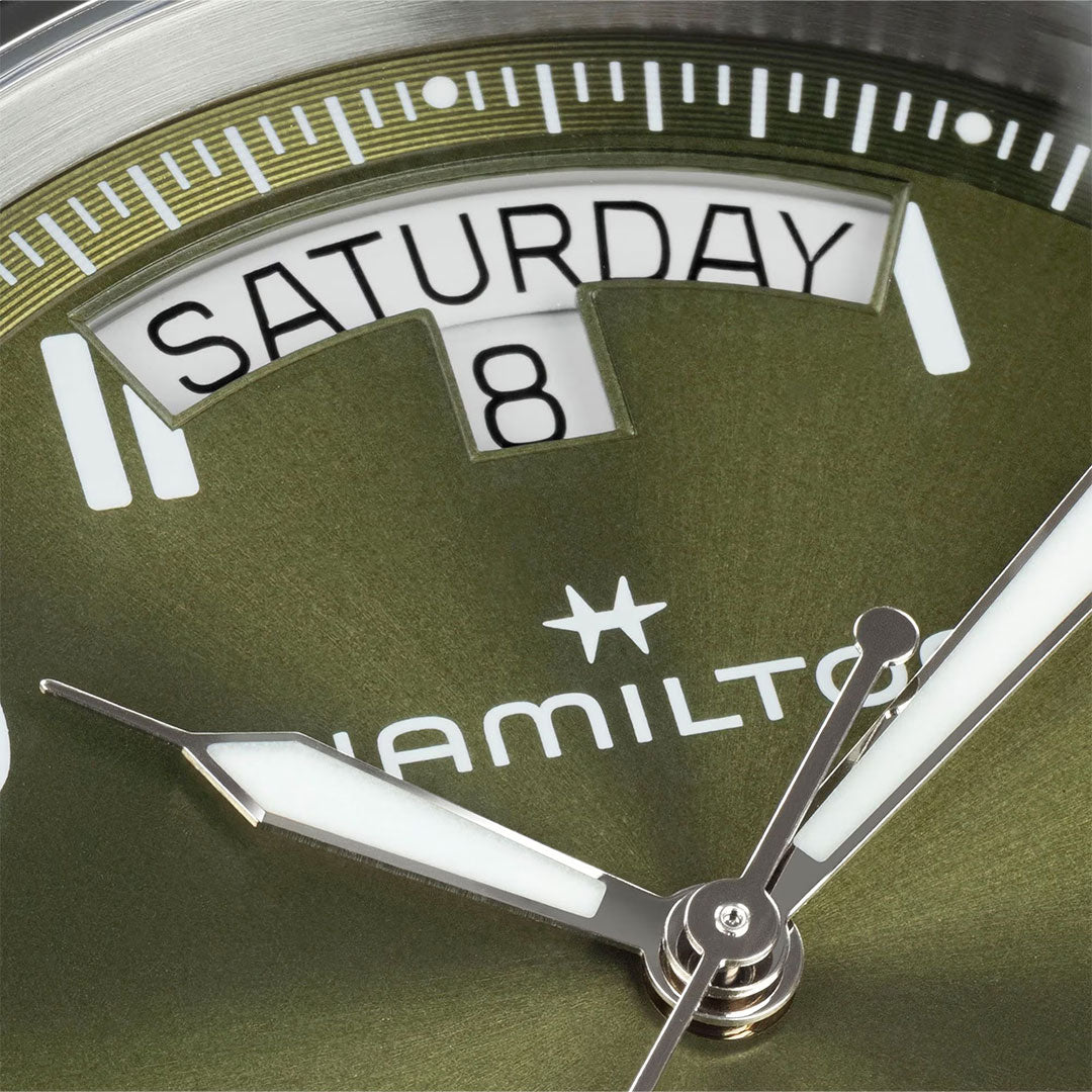 Close-up of the Hamilton Khaki Field King Auto 40mm Watch by Hamilton Watch, featuring a green dial with day ("Saturday") and date ("8") windows, plus silver and white hands—a classic military-inspired design.