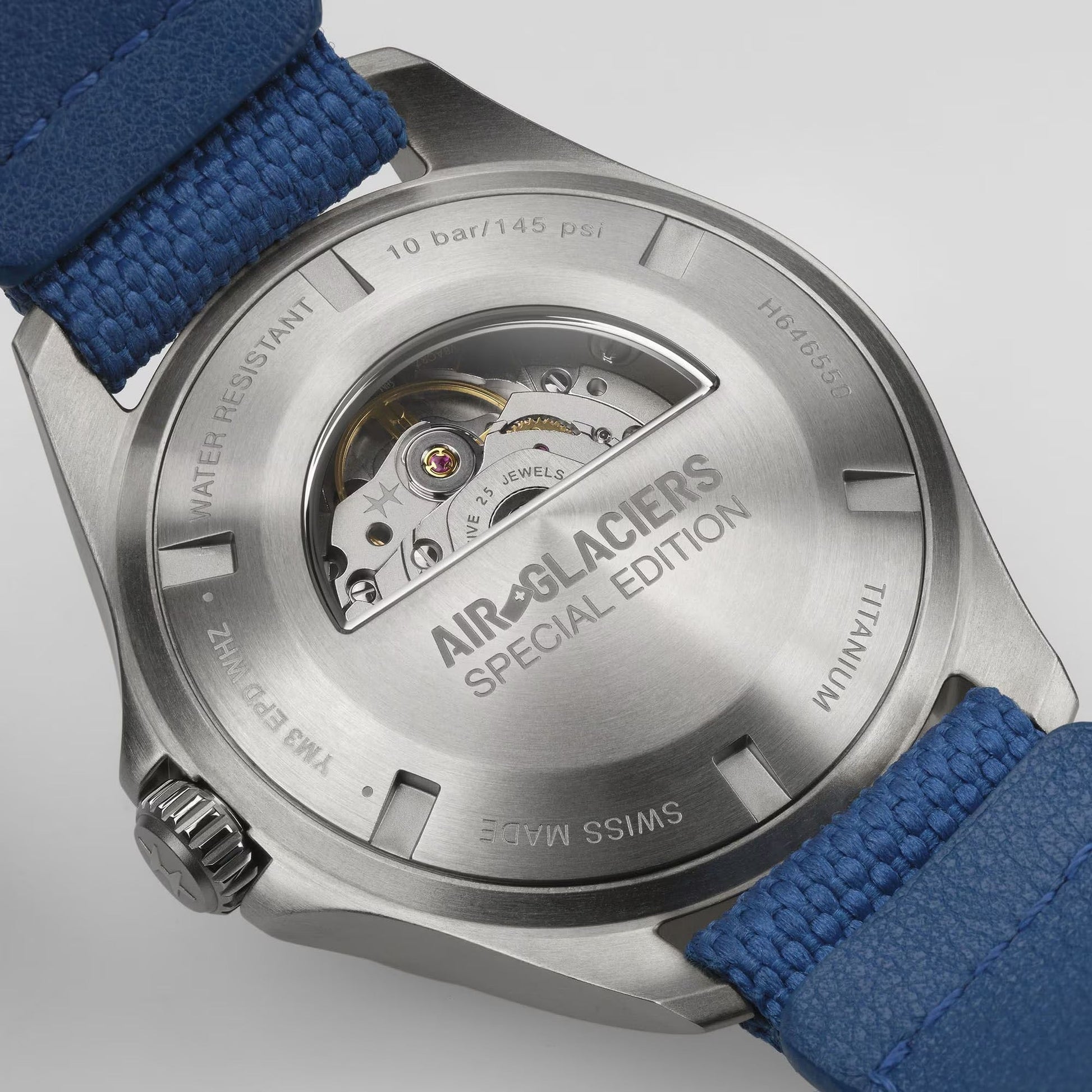 Back of the Hamilton Khaki Aviation Pilot Day Date Air Glaciers Edition Auto 42mm shows a blue strap, titanium case, transparent "AIR-GLACIERS SPECIAL EDITION" caseback revealing H-30 automatic movement and engraved specs. Brand: Hamilton Watch.