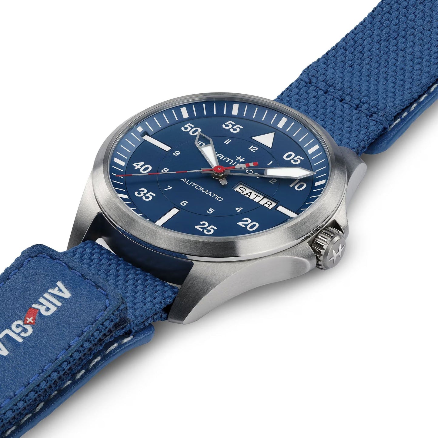 A close-up of the Hamilton Khaki Aviation Pilot Day Date Air Glaciers Edition Auto 42mm by Hamilton Watch, featuring a blue fabric strap, titanium case, blue dial with white numerals, day-date display, and a red-tipped second hand.