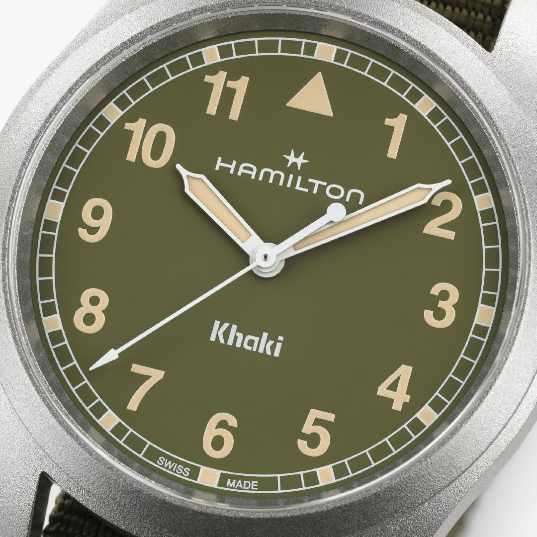 Close-up of the Hamilton Khaki Field Quartz 38mm Watch by Hamilton Watch, featuring a khaki green dial, beige hour markers, silver and beige hands showing 10:10:39, and a metallic silver case for a classic look.