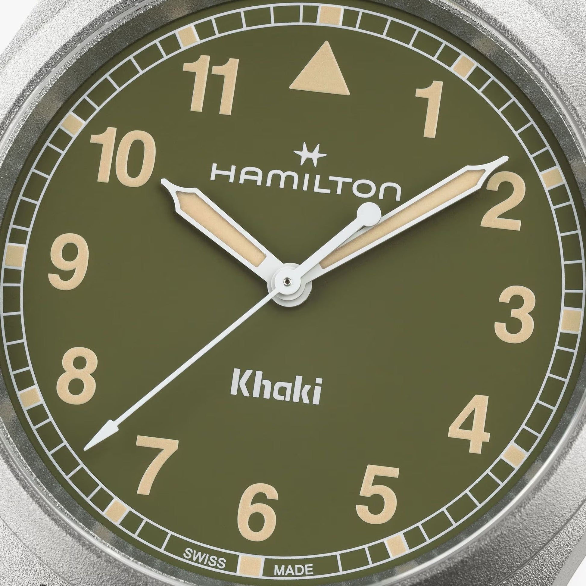 Close-up of the Hamilton Khaki Field Quartz 38mm watch by Hamilton Watch, featuring a green face with beige numerals and hands, a triangle at 12 o'clock, and "Hamilton" and "Khaki" in white—crafted for adventure and precision.