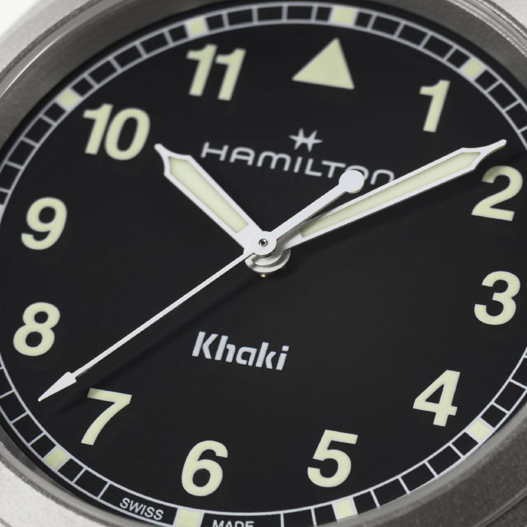 Close-up of the Hamilton Khaki Field Quartz 38mm Watch by Hamilton Watch with a black dial, bold Arabic numerals, luminous hands set to 10:10:36, and "Hamilton" and "Khaki" visible on the face.