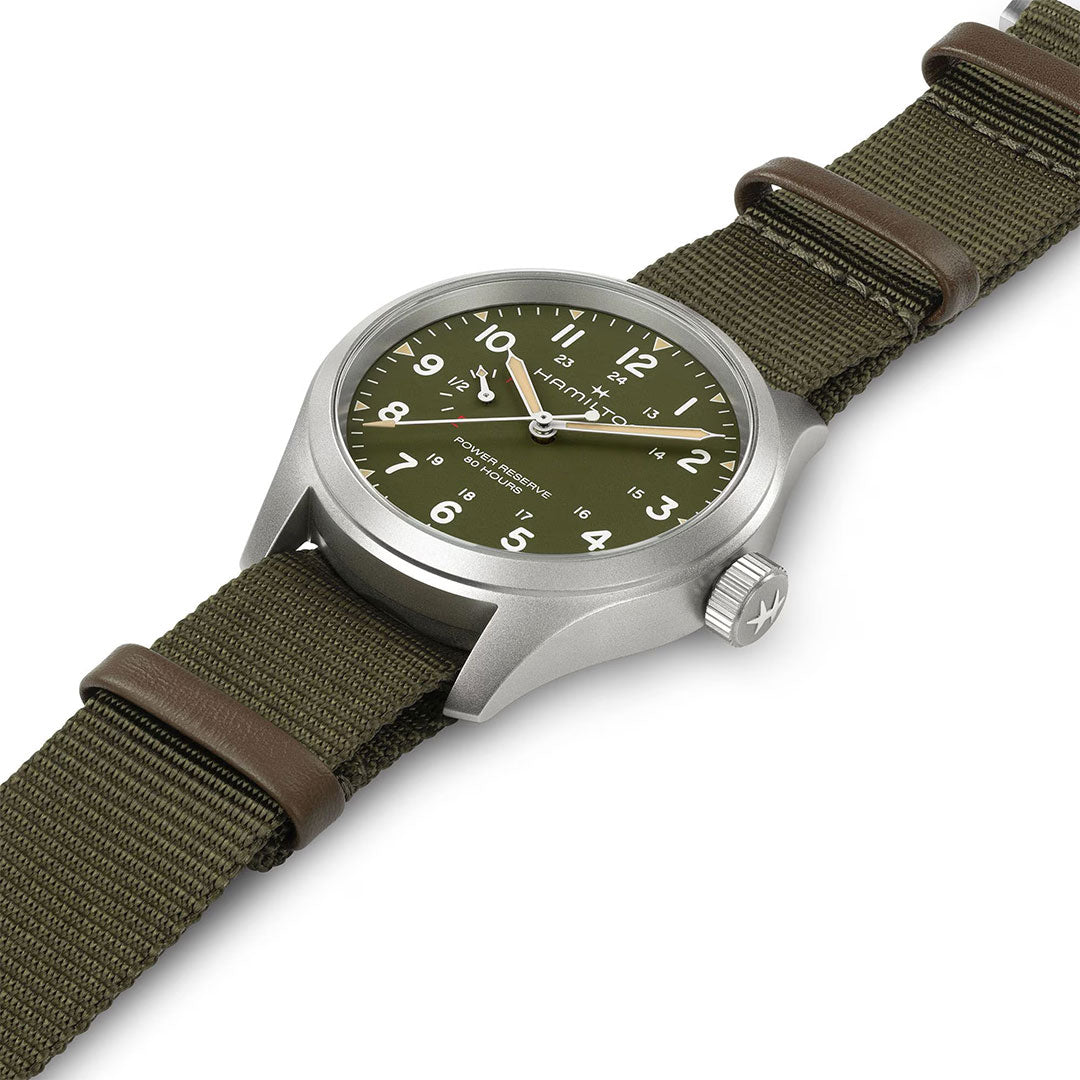 The Hamilton Khaki Field Power Reserve Mechanical 40mm Watch features a green dial with white numerals, a silver case, and a matching green nylon strap with brown leather accents, shown on a white background.