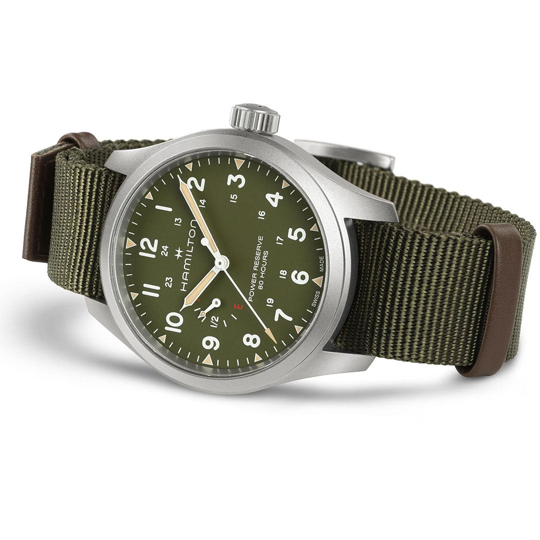 The Hamilton Khaki Field Power Reserve Mechanical 40mm Watch by Hamilton Watch features a green dial with white numerals and a green NATO strap with brown leather accents, displayed at an angle on a white background.