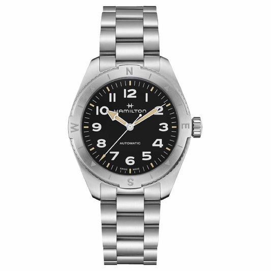 The Hamilton Khaki Field Expedition Automatic 41mm Watch features a silver finish with a black dial, showcasing white Arabic numerals and hands coated with Super-LumiNova. Designed for outdoor adventures, it includes an automatic movement and a stainless steel band. The Hamilton Watch brand name is positioned just below the 12 o'clock mark, enhancing its compass design appeal.