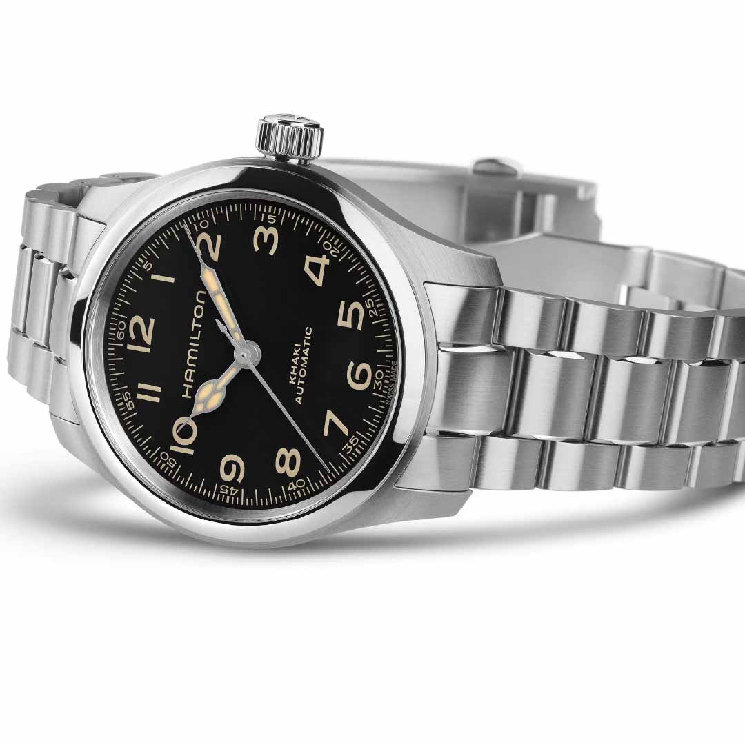 The Hamilton Khaki Field Murph Automatic 38mm Watch is a stainless steel timepiece with a black dial characterized by vintage-style Arabic numerals. Enthusiasts admire its luminescent hands and the prominent Hamilton Watch brand name on its face, elegantly presented at an angle on a light background.