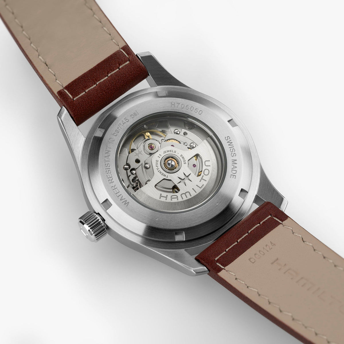 Close-up of the back of a Hamilton Watch Khaki Field Auto 42mm, highlighting its exposed automatic movement and intricate internal mechanics. The leather strap and stainless steel case are also visible, showcasing the rugged charm of this classic military-inspired timepiece.