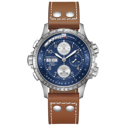 The Hamilton Khaki Aviation X-Wind Auto Chrono 44mm by Hamilton Watch features a silver case, blue dial with three subdials, day-date display, and a brown leather strap with white stitching and metal rivets.