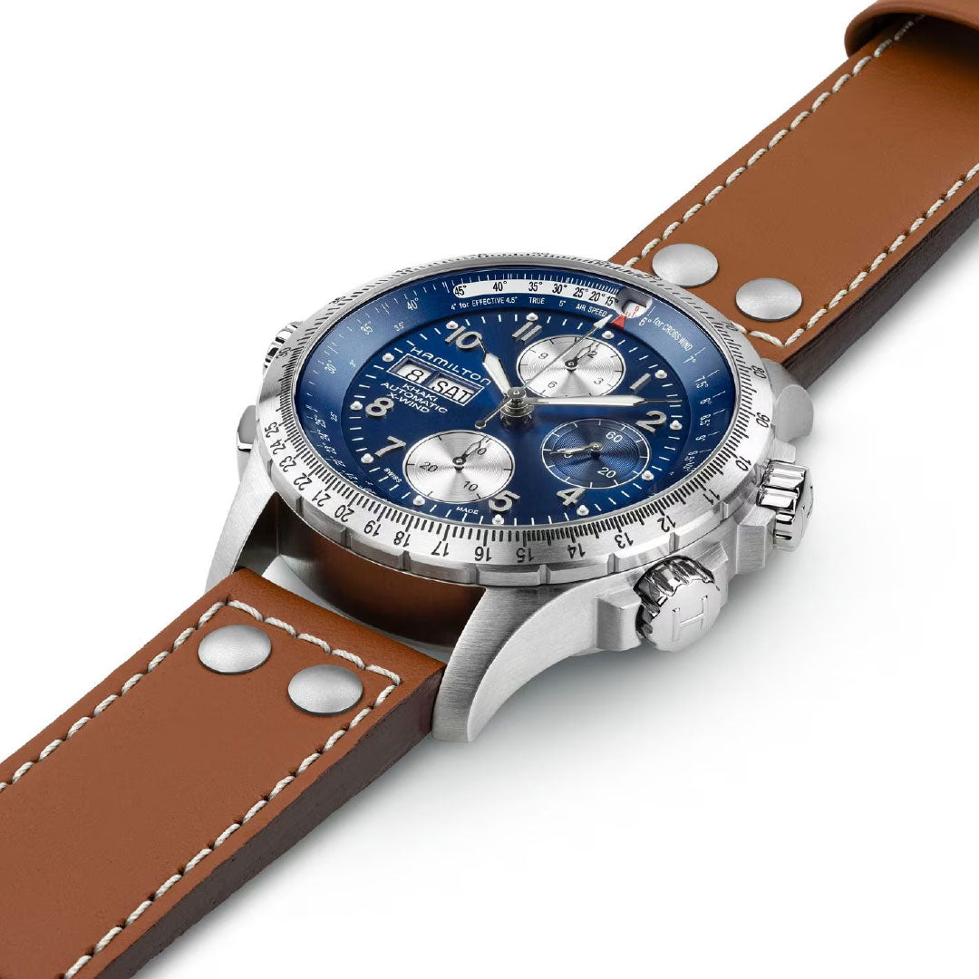 A close-up of the Hamilton Khaki Aviation X-Wind Auto Chrono 44mm Watch by Hamilton Watch, featuring a blue dial with multiple sub-dials, silver case, and brown leather strap with white stitching, plus date and chronograph functions.